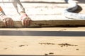 Close up of man builder placing screed rail on the floor covered with sand-cement mix at construction site. Male worker leveling