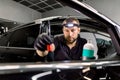 Close up of man, car service station worker, making cleaning and care procedures for car door interior, using brush and Royalty Free Stock Photo