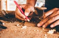 Close-up Man of Carpenter using pencil equipment drawing and plan design on wooden product. Small business Concept