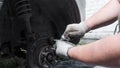 Close up. A man changes a wheel in his garage