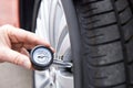 Close-Up Of Man Checking Car Tyre Pressure With Gauge Royalty Free Stock Photo