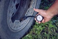 Close-up of a man checking and measuring tire pressure.