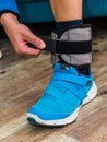 Close up of a man closing velcro strap on ankle weight