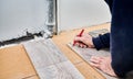 Male worker hands drawing mark on laminate board. Royalty Free Stock Photo