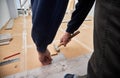 Male worker with hammer installing laminate floor in apartment. Royalty Free Stock Photo