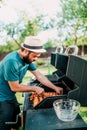 Close up of man cooking on grill,  having beers and cooking on garden barbecue. Lifestyle, leisure concept Royalty Free Stock Photo