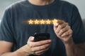 Close up of man customer giving a five star rating on smartphone. Review, Service rating, satisfaction, Customer service Royalty Free Stock Photo