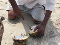 Close up of man cutting a coconut with a big Indian knife. Sale of coconuts. Indian beach market