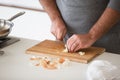 Close up of man cutting garlic on wooden board Royalty Free Stock Photo