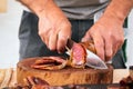 Close-up of a man cutting Iberian sausage on a wooden board Royalty Free Stock Photo