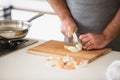 Close up of man cutting onion on wooden board Royalty Free Stock Photo