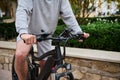 Close-up of a man cyclist riding an electric bike, bicycle in the city street. Bike sharing city service. Copy ad space Royalty Free Stock Photo