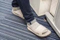 Man with dark blue jeans wear grey slippers with socks in office Royalty Free Stock Photo