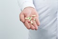 Close up of man doctor hand holding pills on white background Royalty Free Stock Photo