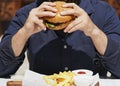 Close up of man eating burger and french fries Royalty Free Stock Photo