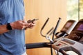 Close Up Of Man Exercising On Treadmill At Home Wearing Smart Watch Checking Mobile Phone Royalty Free Stock Photo