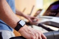 Close Up Of Man Exercising On Treadmill Wearing Smart Watch Checking Mobile Phone Royalty Free Stock Photo