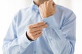 Close up of man fastening buttons on shirt sleeve Royalty Free Stock Photo