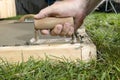 Close up of man finishing cement slab with edger