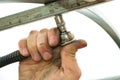 a man fixes the frame of the greenhouse with fixing bolts