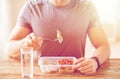 Close up of man with fork and water eating food