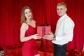 Close-up of man giving red giftbox to happy girl Royalty Free Stock Photo