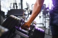 Close-up man grabs a heavy dumbbell in gym with his hand. Concept lifting, fitness Royalty Free Stock Photo