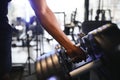 Close-up man grabs a heavy dumbbell in gym with his hand. Concept lifting, fitness Royalty Free Stock Photo