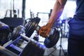 Close-up man grabs a heavy dumbbell in gym with his hand. Concept lifting, fitness Royalty Free Stock Photo