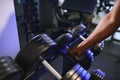 Close-up man grabs a heavy dumbbell in gym with his hand. Concept lifting, fitness Royalty Free Stock Photo