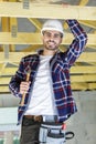 Close up man hammers nail in wooden beam Royalty Free Stock Photo