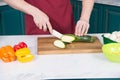 Close up zucchini cut on slice by knife. Orange and red paprika on table with cut green zucchini. Green vegetables Royalty Free Stock Photo