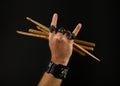 Man hand with drumsticks and devil horns on black Royalty Free Stock Photo