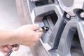 Close up man hand holding mechanic inflating tire and checking air pressure with gauge pressure in service station Royalty Free Stock Photo