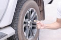 Close up man hand holding mechanic inflating tire and checking air pressure with gauge pressure in service station Royalty Free Stock Photo