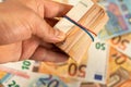 Close up of man hand holding roll of euro money bill on a money background, Euro money of European Union