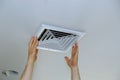 Close up man hand installing vent cover from ceiling Royalty Free Stock Photo