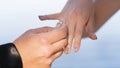 Close up of man hand putting a wedding gold ring on the woman finger. Action. Exchange rings for wedding registration of Royalty Free Stock Photo