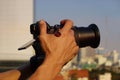 Man hand shooting a video with a building and city view