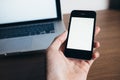 Close up of man hand with smartphone and laptop