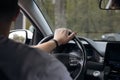 Man driving car, hand on steering wheel, close-up in natural light. Royalty Free Stock Photo