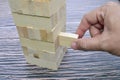 Close up man hand take one block on The tower from wooden blocks Royalty Free Stock Photo