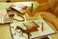 Close up Man hand using calculator and writing make note with calculate about cost at home office Royalty Free Stock Photo