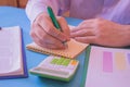 Close up Man hand using calculator and writing make note with calculate about cost at home office. Business concept. The Man are Royalty Free Stock Photo