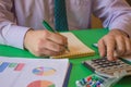 Close up Man hand using calculator and writing make note with calculate about cost at home office. Business concept. The Man are Royalty Free Stock Photo