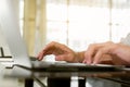 Close up man hand using laptop for work at home. Student hand doing his homework with laptop Royalty Free Stock Photo