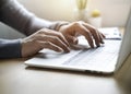 Close-up of man hand using and typing keyboard of laptop computer on office desk. Royalty Free Stock Photo