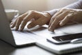 Close-up of man hand using and typing keyboard of laptop computer on office desk. Royalty Free Stock Photo