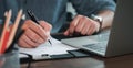 Close-up of man hand using writing pen memo on notebook paper or letter, diary on table desk office. Royalty Free Stock Photo