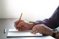 Close-up of man hand using writing pencil memo on notebook paper Royalty Free Stock Photo